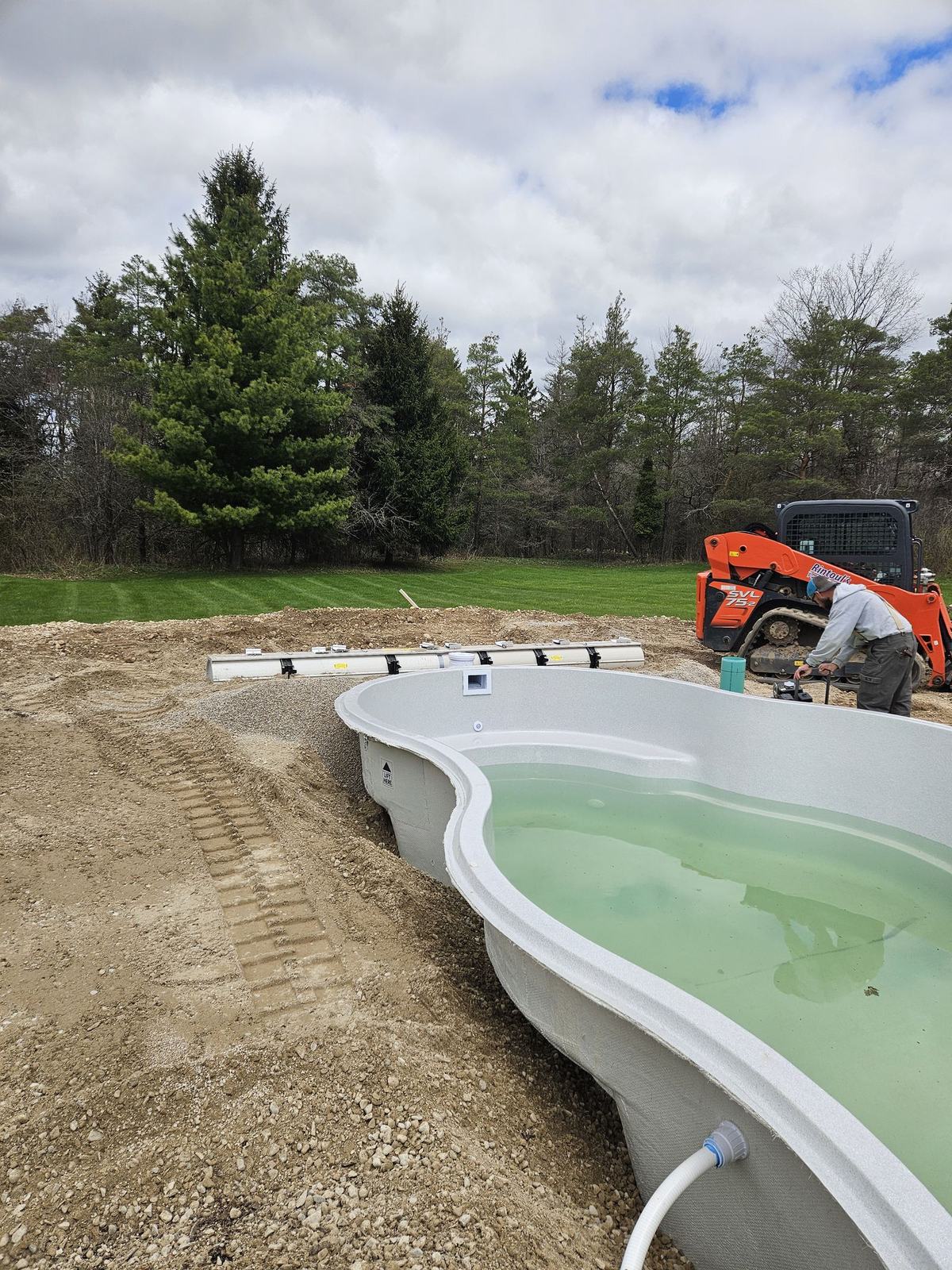 Rintoul's crew working on a new fibreglass pool as it fills with water